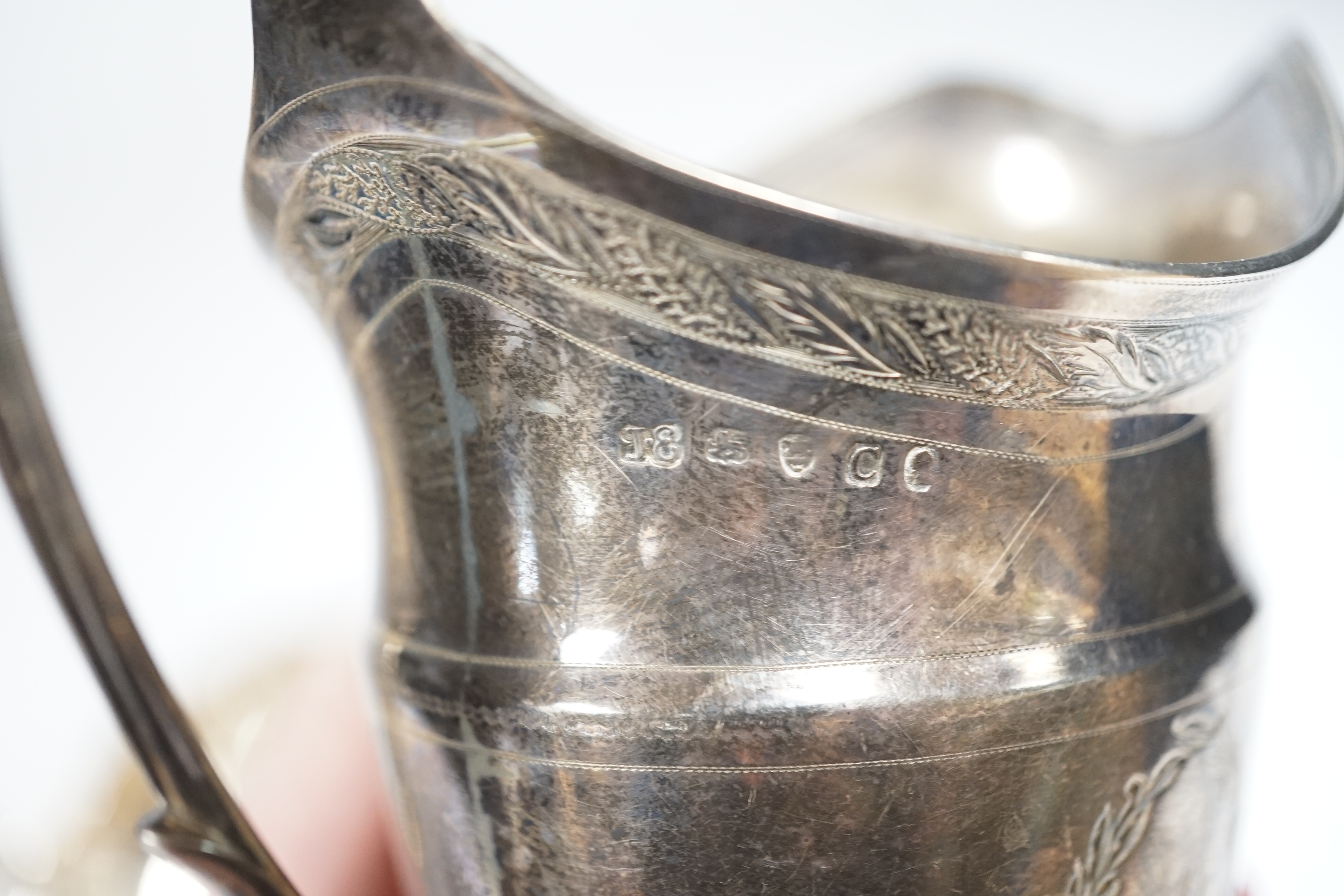 A George III engraved silver helmet shaped cream jug, John Eames, London, 1798, 11.1cm, a Japanese Suzuyo 950 white metal two handled shallow bowl, a George V silver two handled presentation trophy cup and a silver circu